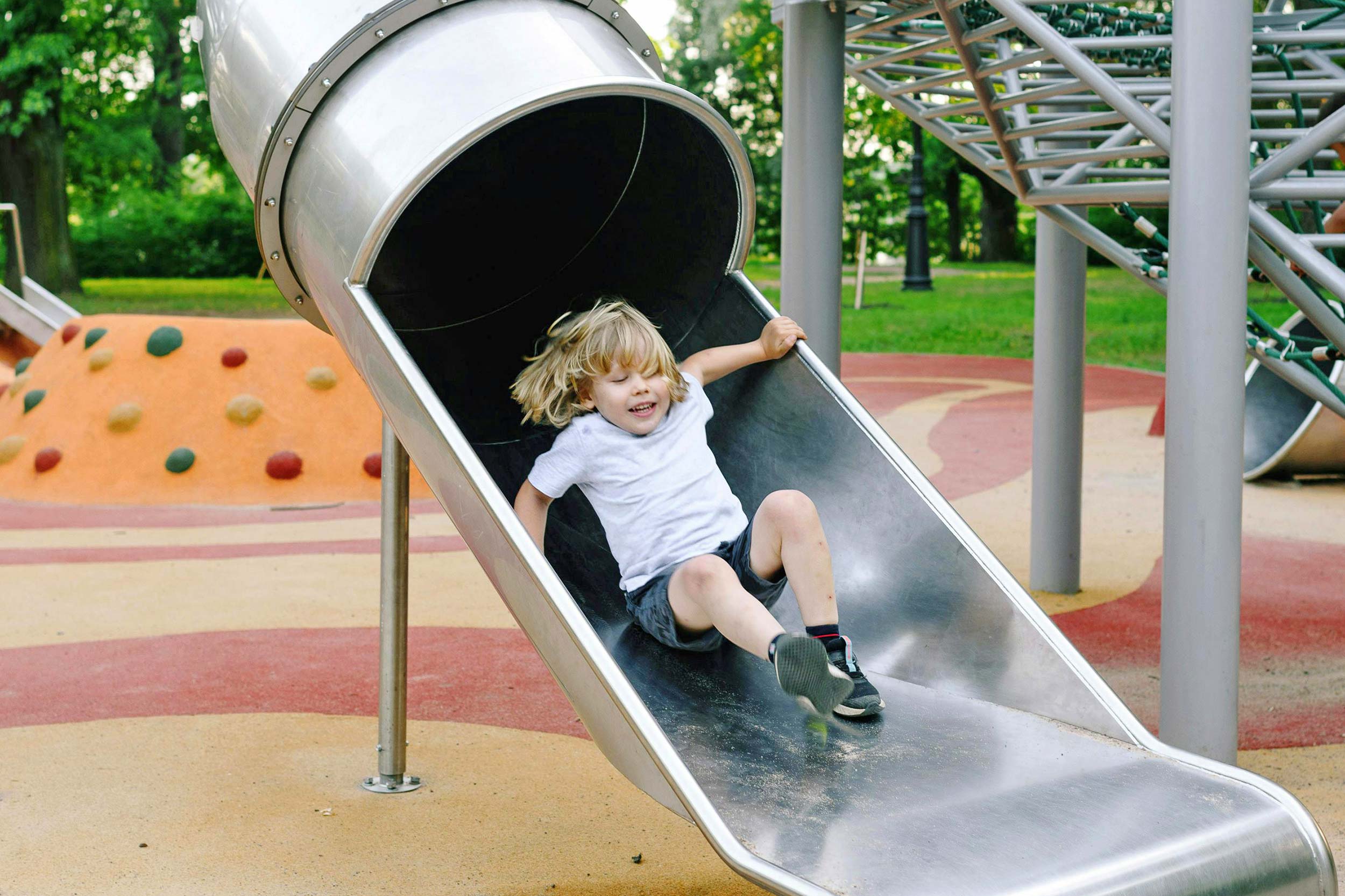 Child on slide in play area
