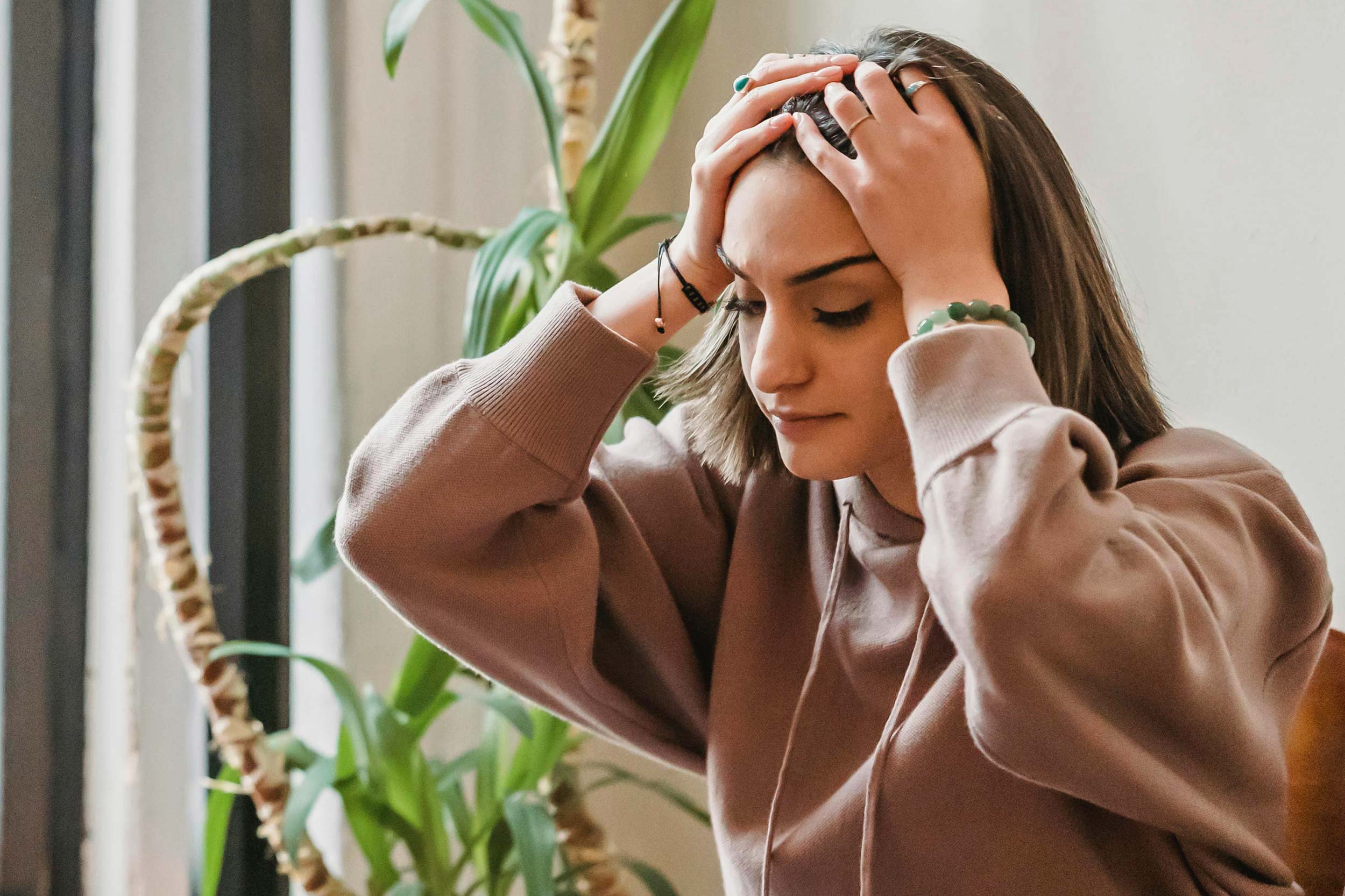 An unhappy person holding their head